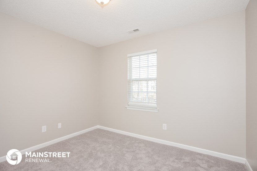 the upstairs bedroom with carpet and window