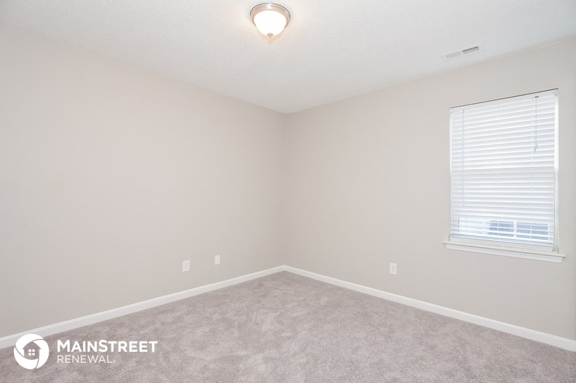 the upstairs bedroom with carpet and window