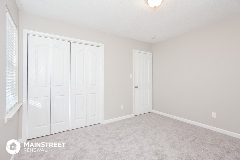 a bedroom with two closets and a carpeted floor