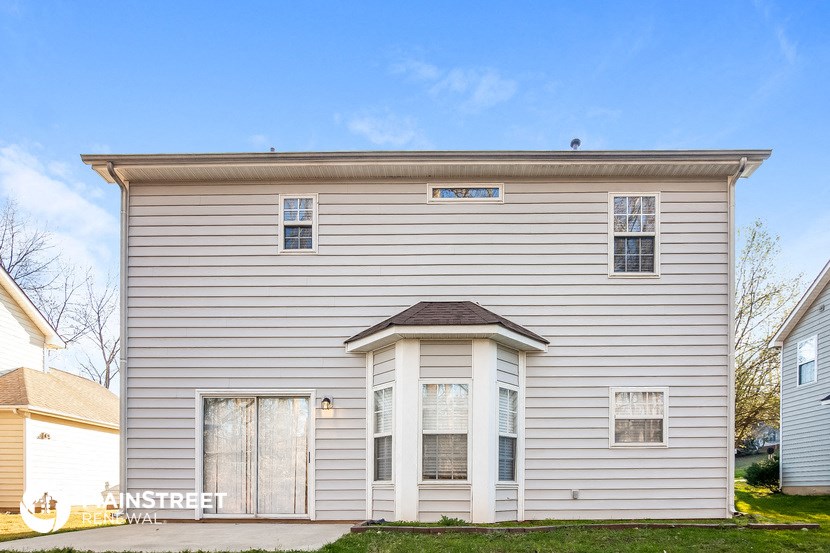 the front of a white house with a garage door