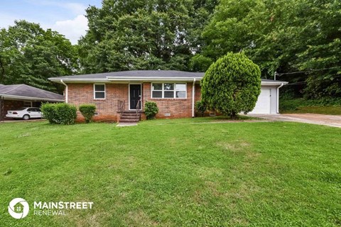 a small brick house with a lawn in front of it