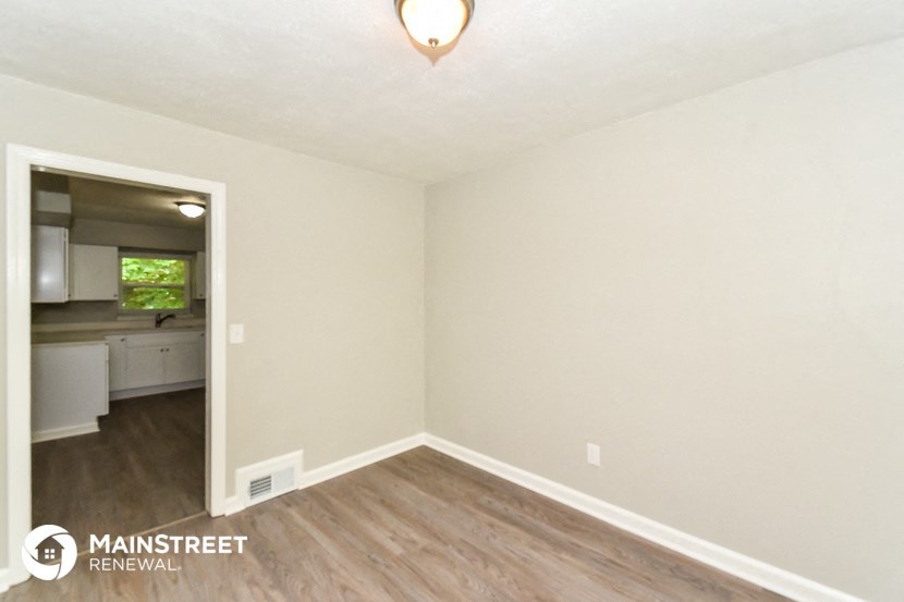 the renovated living room and dining room with wood flooring