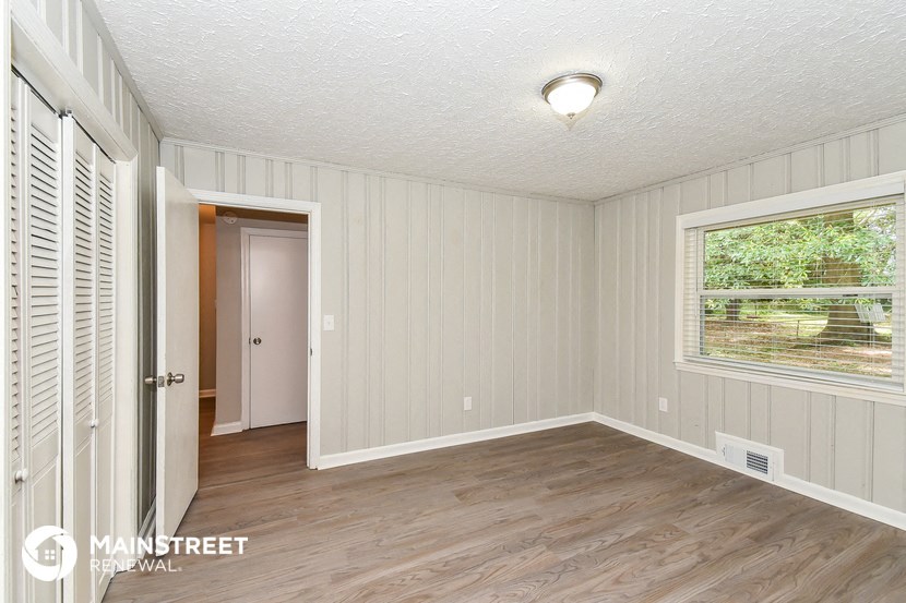 a small room with a door to a hallway and a window