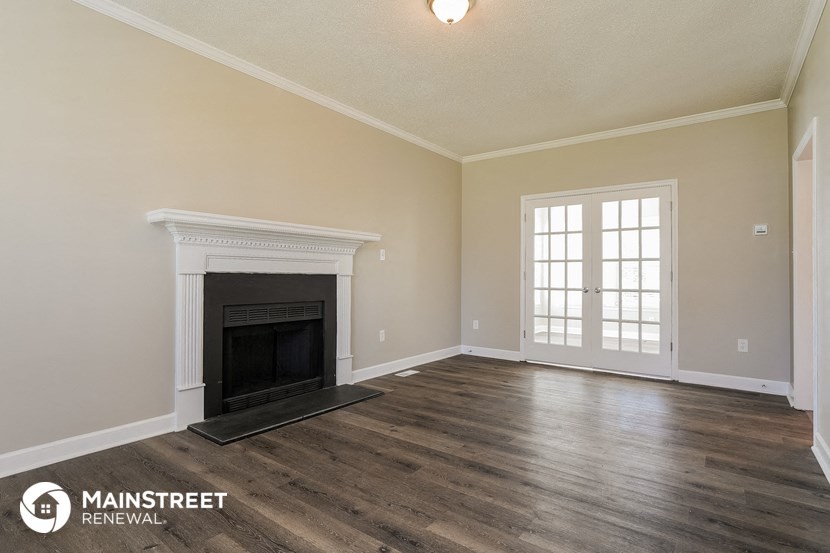 the living room of an empty house with a fireplace