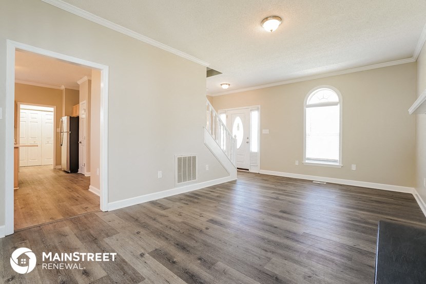 the living room and dining room of an empty house with wood floors