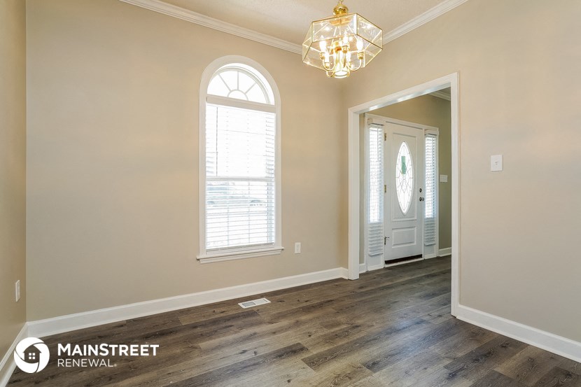 a living room with a door and a chandelier