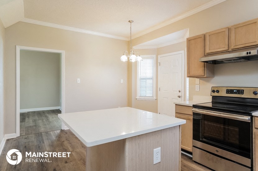 a kitchen with a white counter top and an oven and a stove