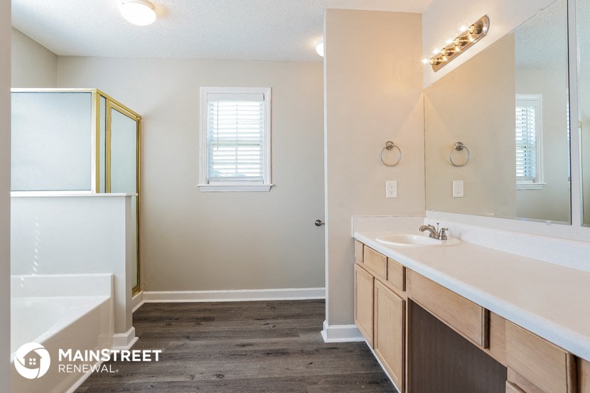 a bathroom with a tub and a sink and a mirror