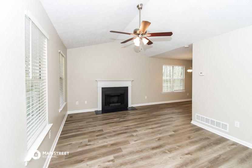 a living room with a fireplace and a ceiling fan
