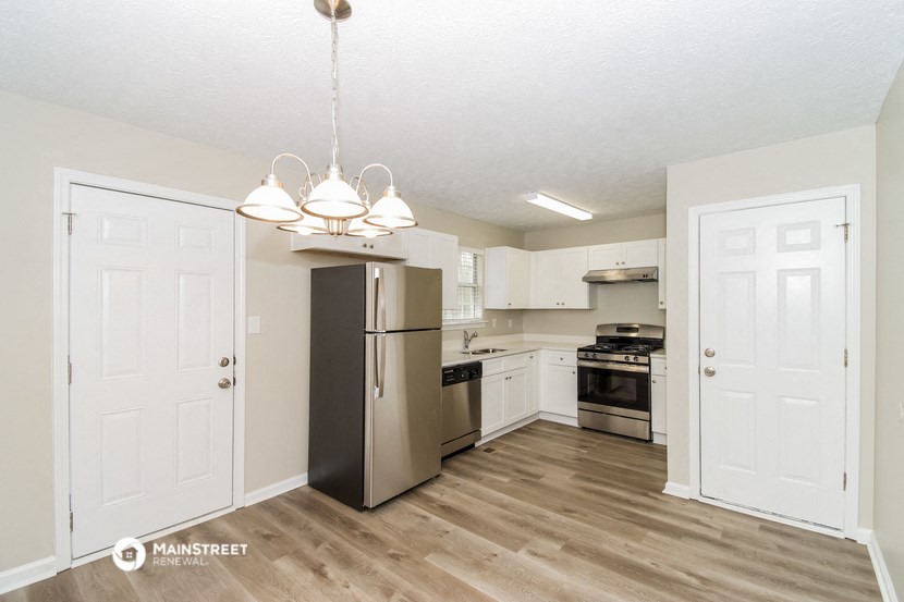 a renovated kitchen with stainless steel appliances and white cabinets