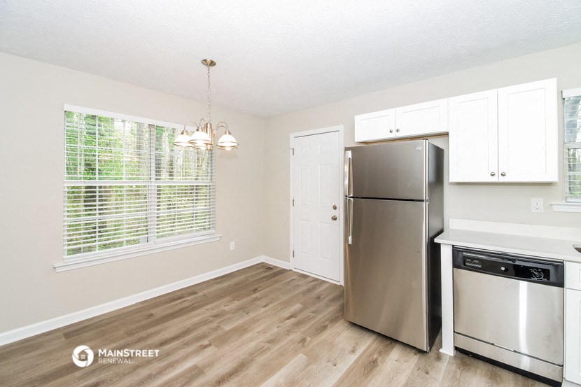 an empty kitchen with stainless steel appliances and a large window