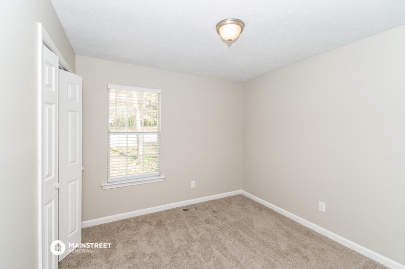 a bedroom with a carpeted floor and a window