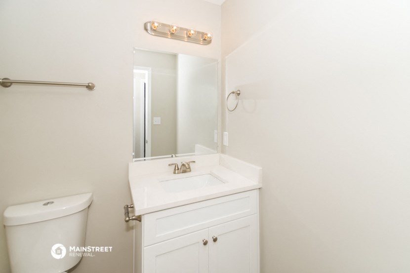 a bathroom with a sink and a mirror and a toilet