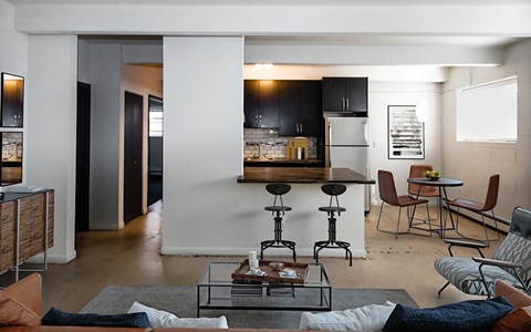 A modern living room with a glass coffee table and a bar area.