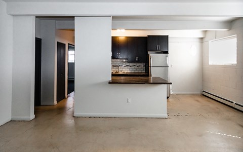 A kitchen with a refrigerator, sink, and cabinets is shown.