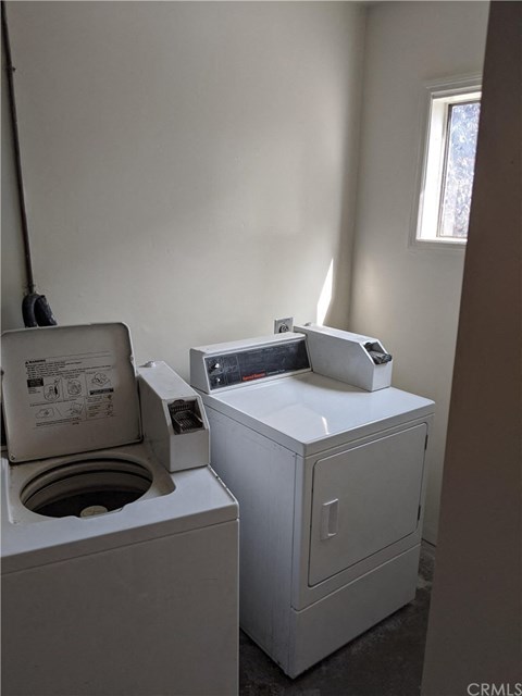 a room with a washing machine and a toilet in it