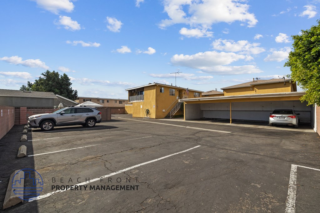 a parking lot with two cars in front of a building