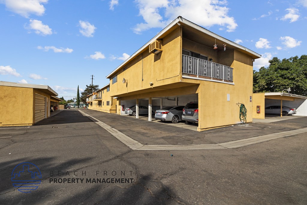 a yellow building with cars parked in front of it on a street