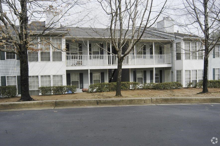 a white apartment building with trees in front of it