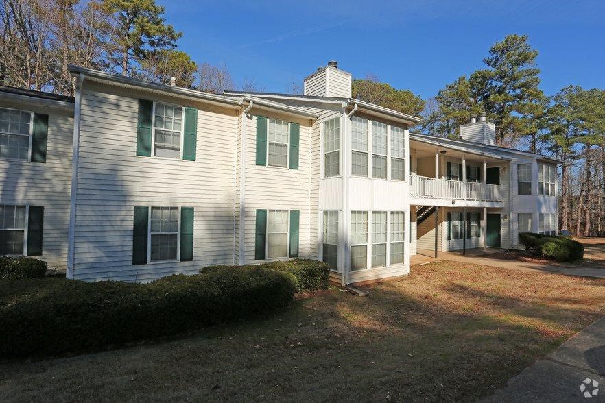 a white house with green shuttered windows and a yard