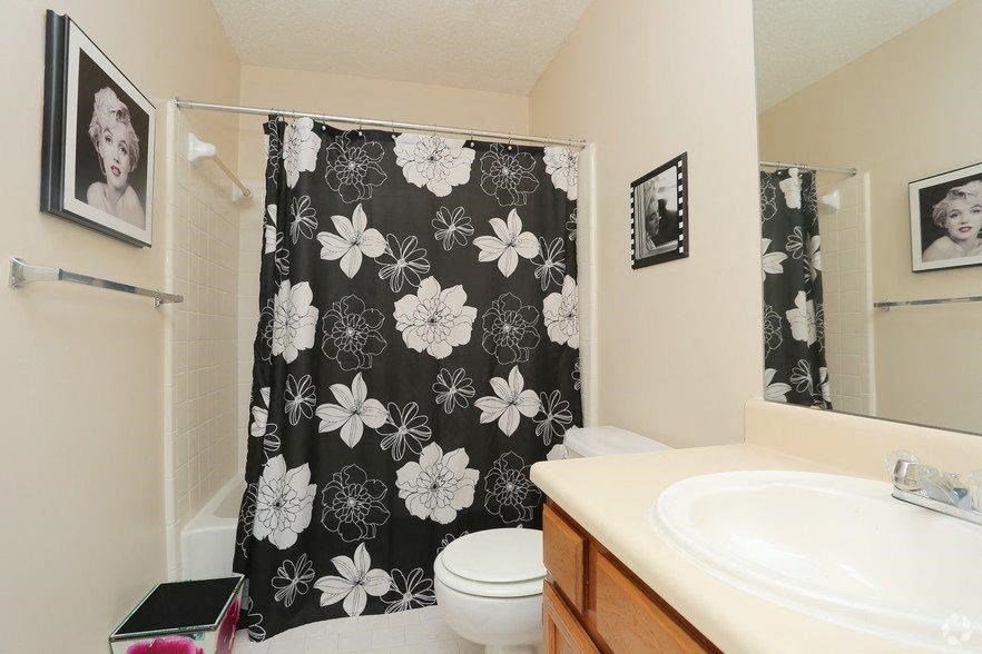 a bathroom with a black and white shower curtain