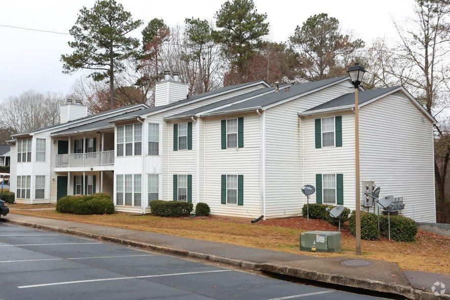a white house with green shutters on a street