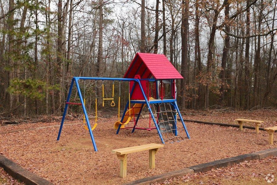 a playground with a swing set and a red swing
