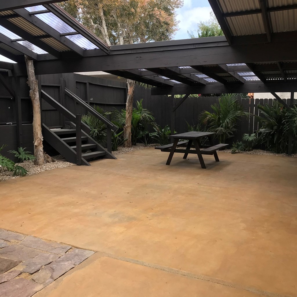 a patio with a picnic table and a metal roof