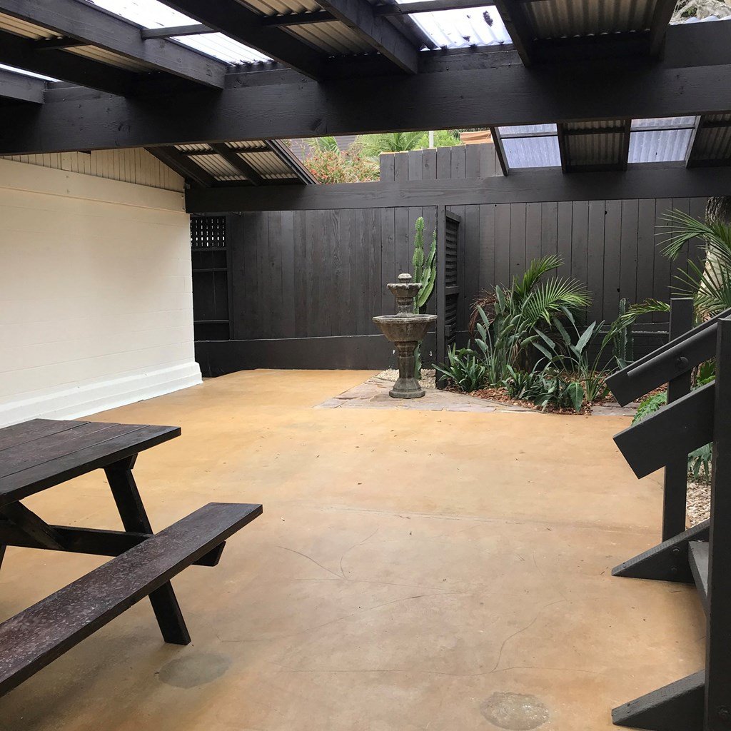 a courtyard with picnic tables and a water fountain