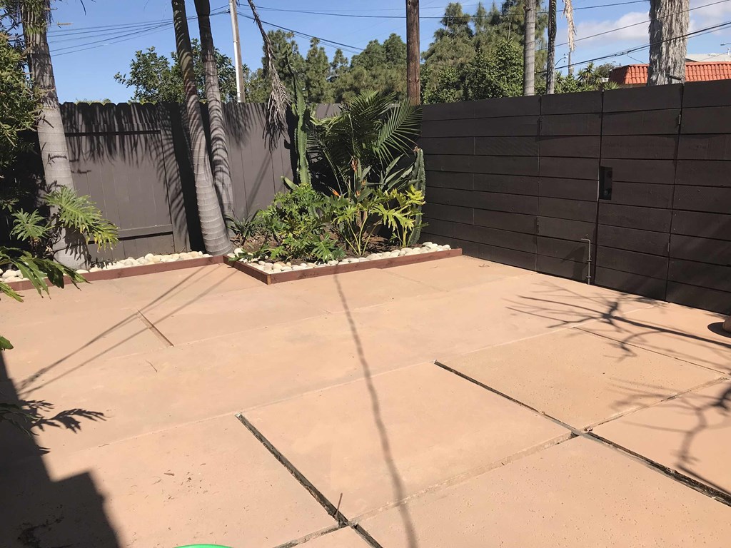 a backyard with a concrete patio and a fence