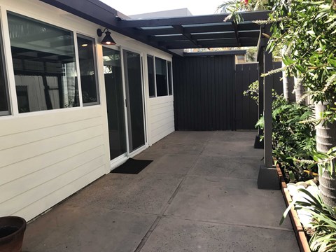 the side entrance to the house with a concrete walkway and glass doors