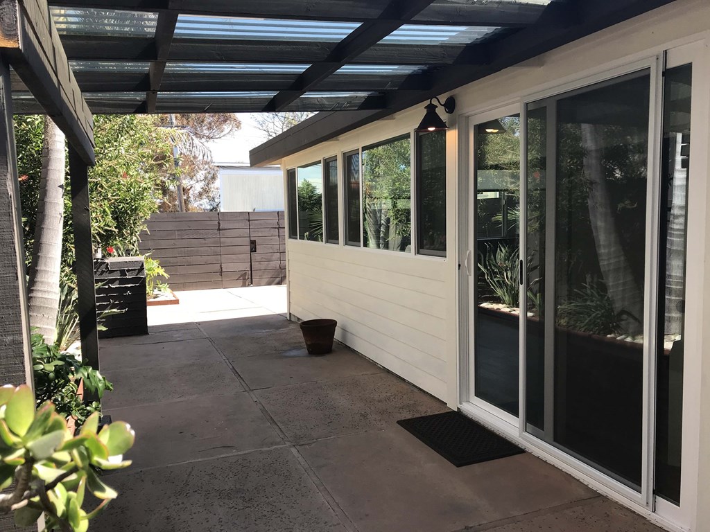 a patio with sliding glass doors and a roof