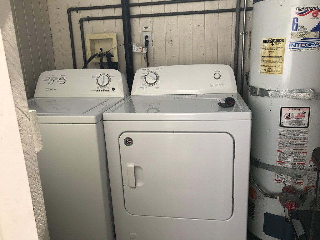 two washers and a dryer in a small room