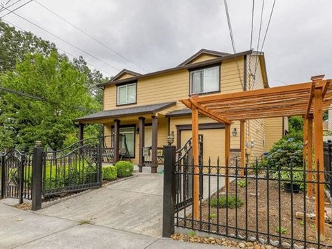 A house with a black fence and a brown roof.