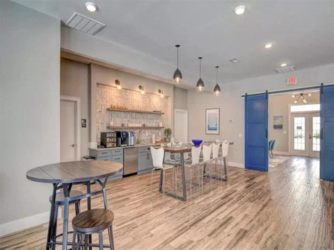 a living room with a kitchen and a bar with stools
