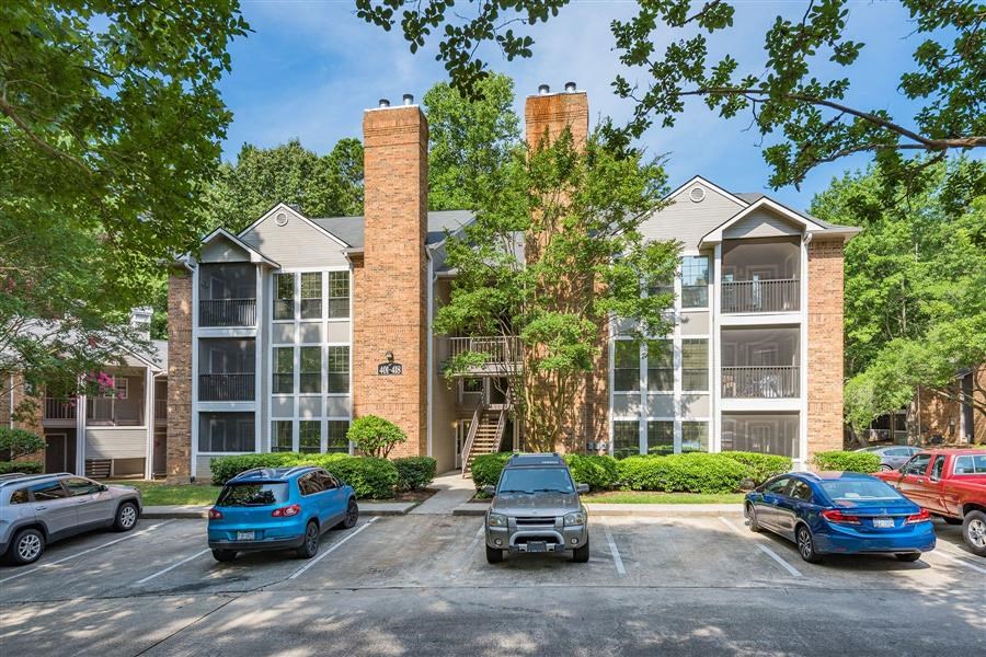 an apartment building with cars parked in a parking lot
