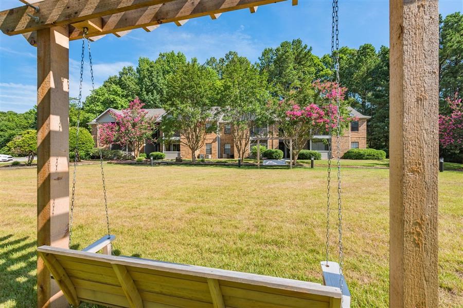 a swing in a yard with a house in the background