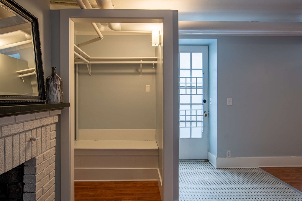a walk in closet with a door to a room with a fireplace