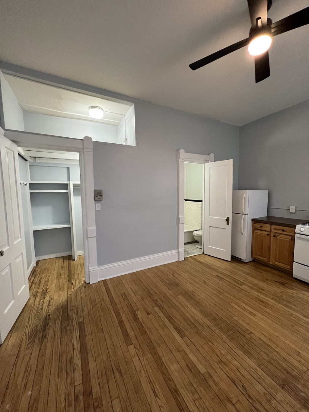 a living room with a hard wood floor and a ceiling fan
