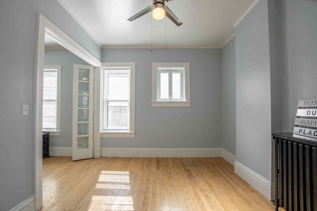 an empty room with blue walls and a ceiling fan