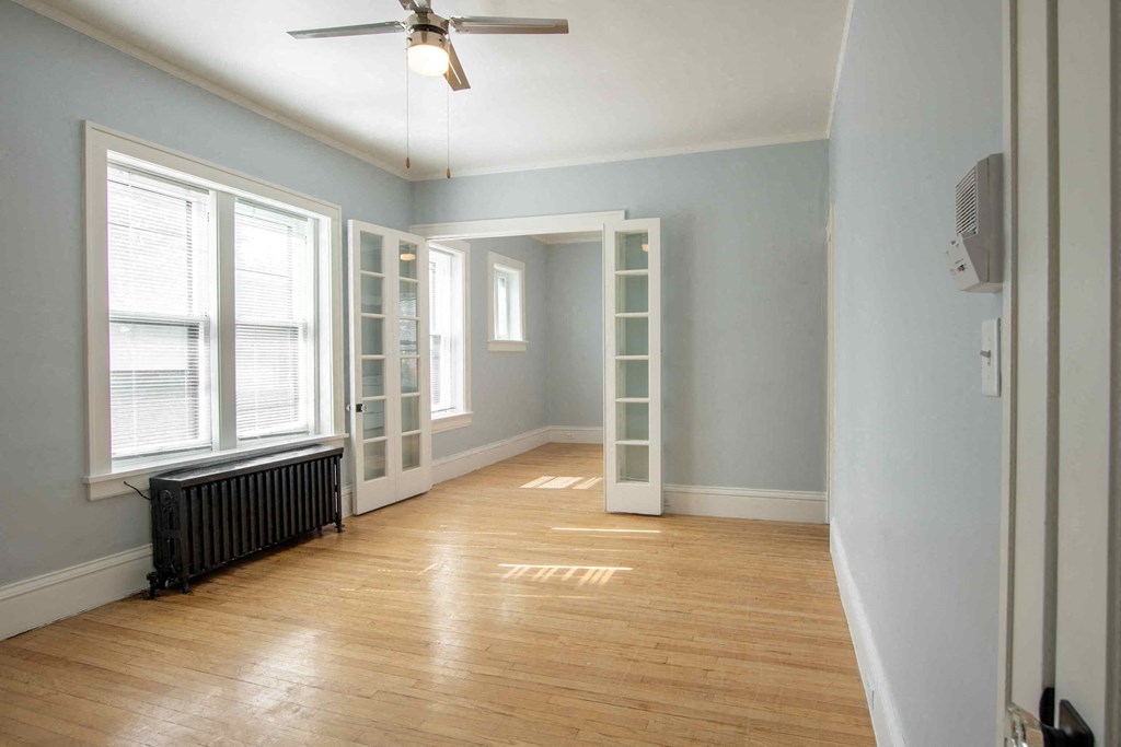 a living room with a hard wood floor and a ceiling fan
