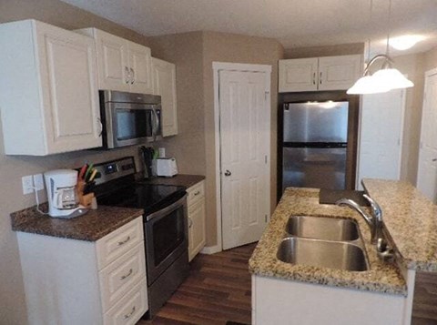 a kitchen with a sink a stove and a refrigerator