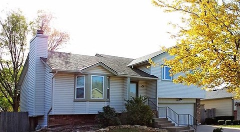 a white house with a tree in front of it