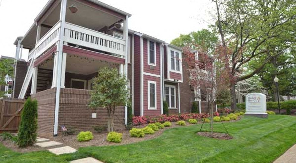 a red brick house with a porch and a lawn