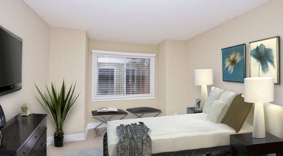 a bedroom with a bed and a tv and a window