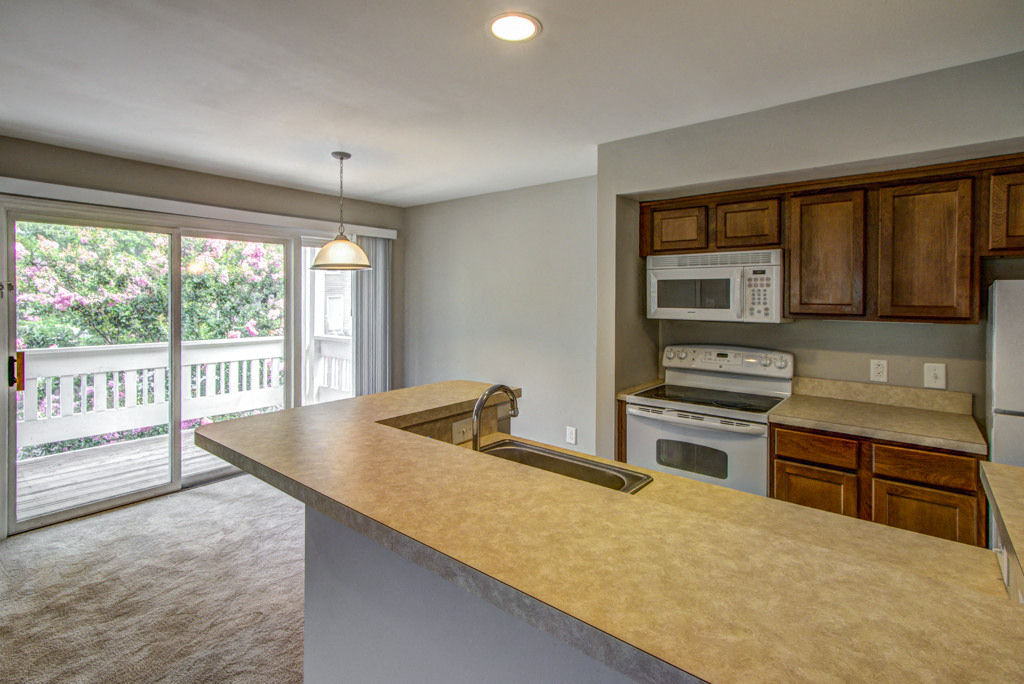 an empty kitchen with a sink and a counter top