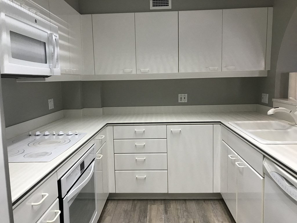 a kitchen with white cabinets and a stove and a microwave