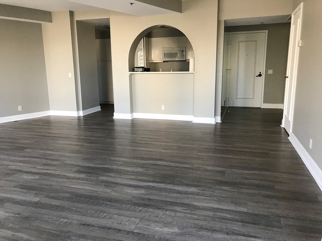 a living room with a hard wood floor and a kitchen