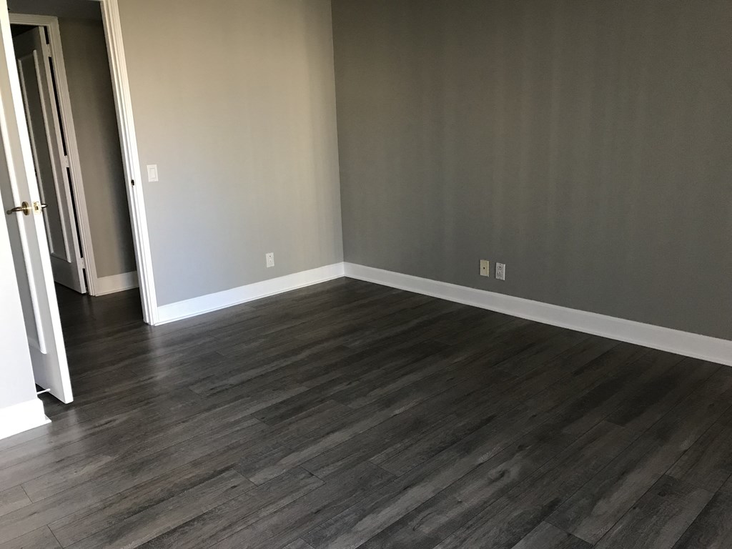 a living room with wood floors and gray walls and a door