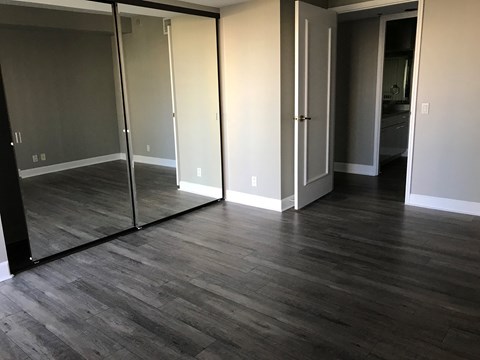 a living room with a hard wood floor and mirrors